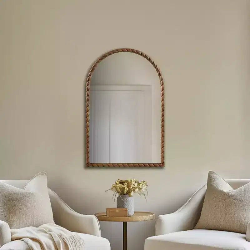 Un miroir décoratif mural arqué avec un élégant cadre en bois d'hévéa tressé.