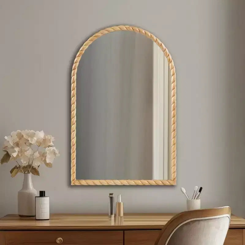 Un miroir décoratif mural arqué avec un élégant cadre en bois d'hévéa tressé.